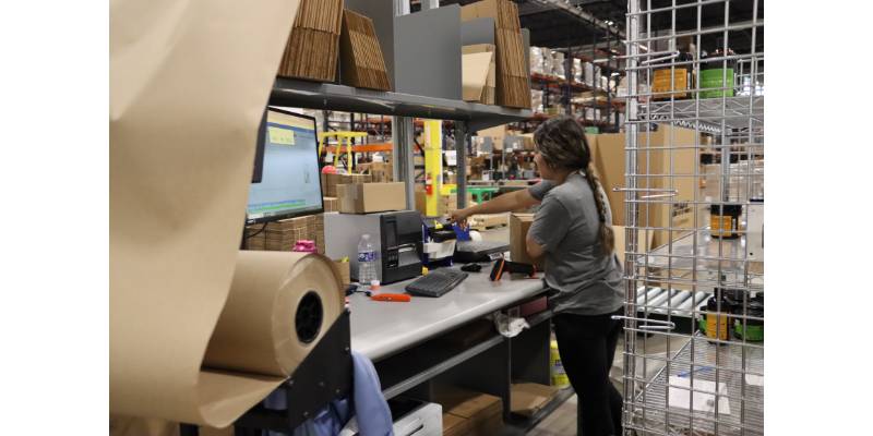 Worker carefully checks that the box is sized correctly for the package