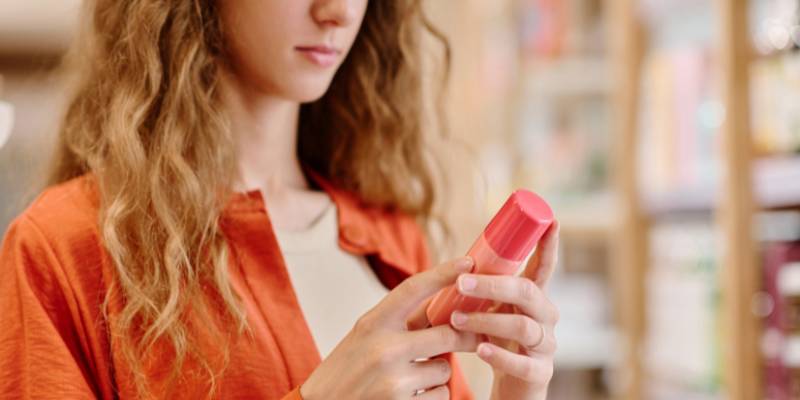 Woman reading label on cosmetic