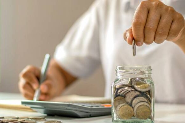 Putting coins in a jar while reviewing increased shipping costs.