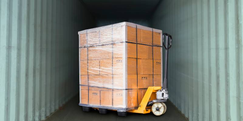 Dolly loaded with a pallet of product inside a truck as part of the shipping process at a fulfillment center.