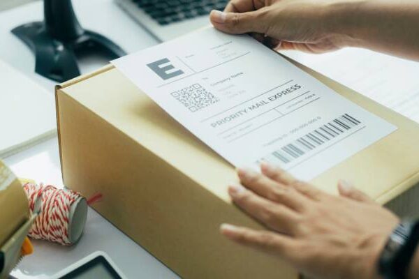 placing a priority mail label on a box for shipping to a customer